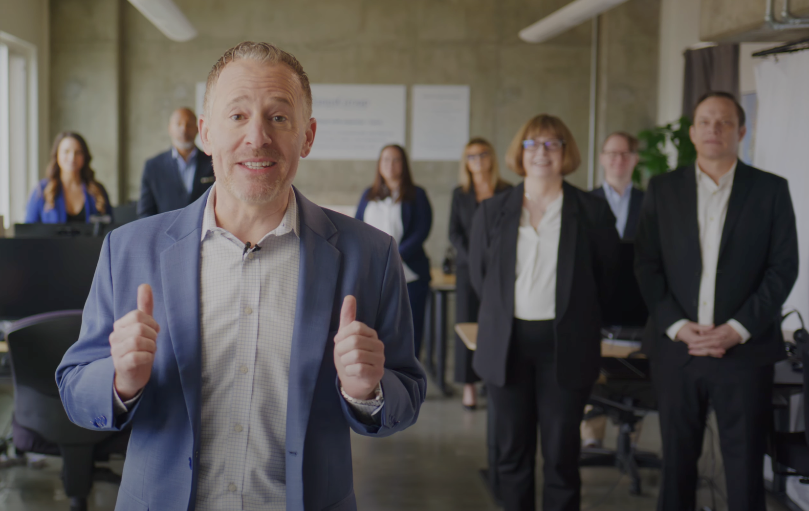 A group photograph of Aaron Janus and the team of Seattle property management experts at REMAX Integrity Property Management - standing in their Seattle office
